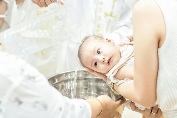 Orthodox priest baptizing a baby during christening in Cyprus